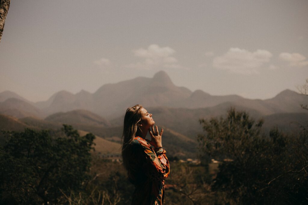 woman standing in the mountains wondering about the dangers of marijuana during recovery