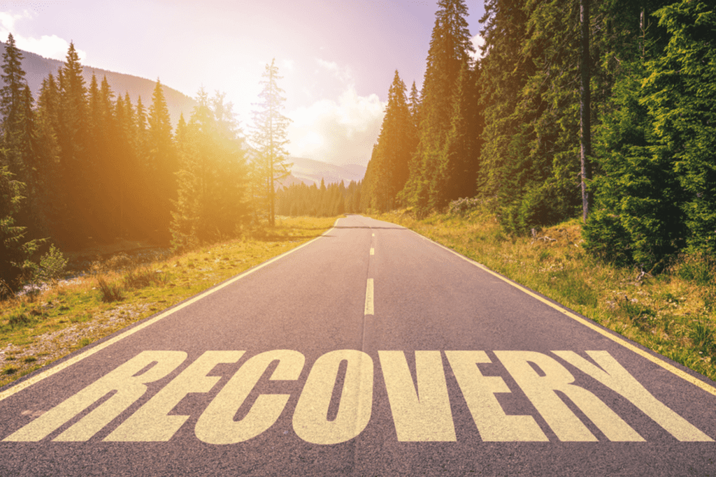 Recovery word written on road in the mountains