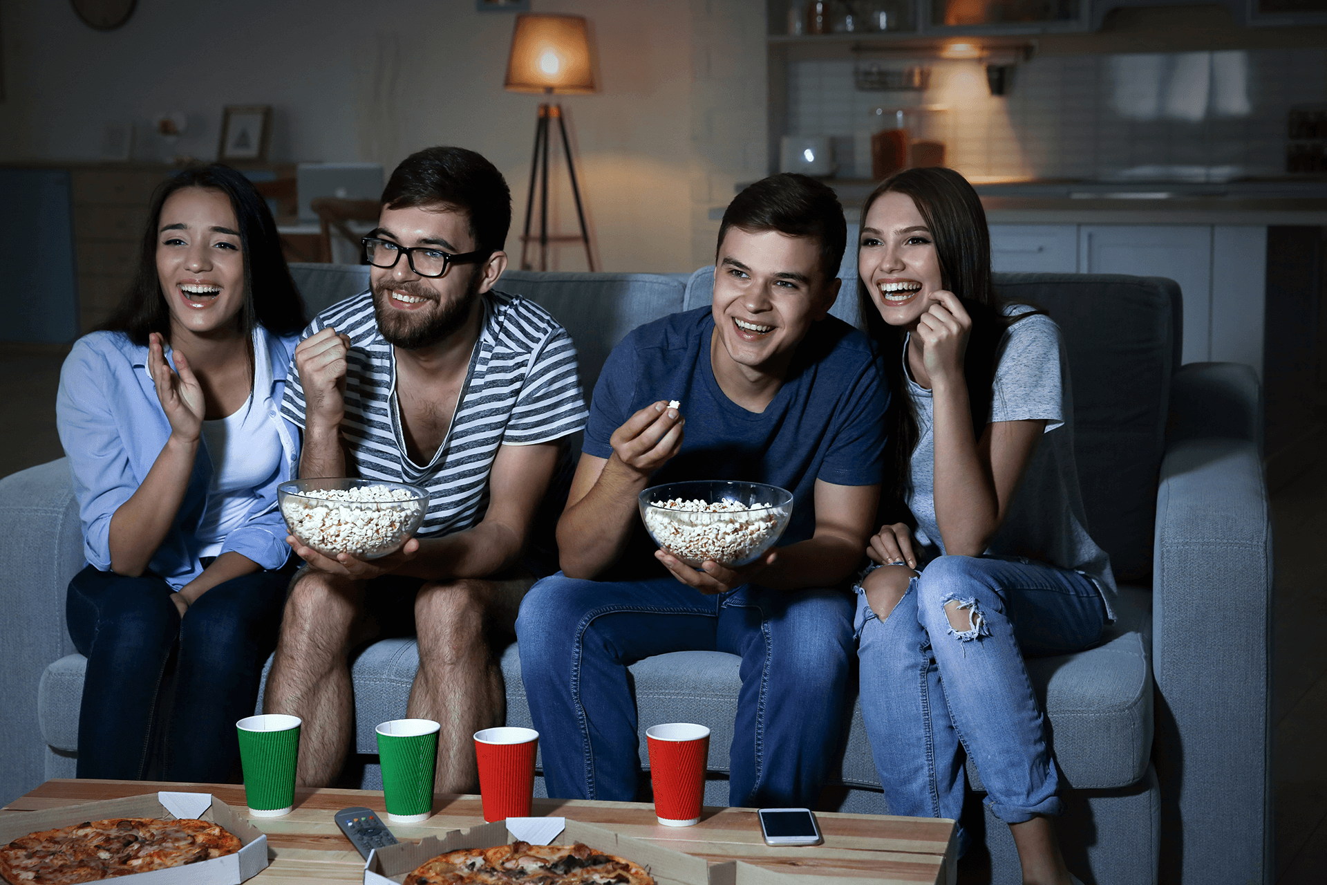 Friends watching TV in evening at home
