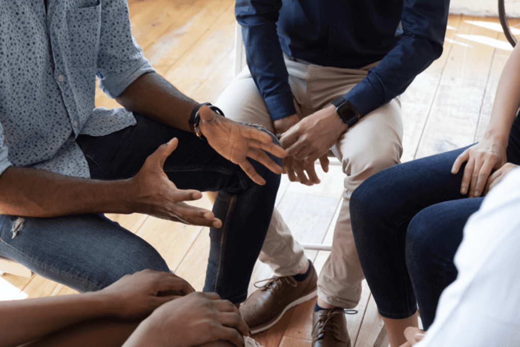 group of people sitting around in a circle discussing high end rehab