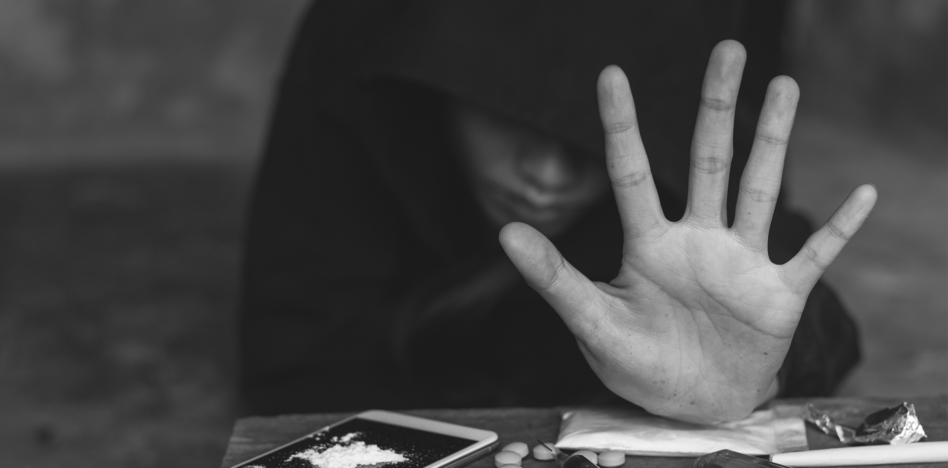 person reaching for drugs to show drug addiction