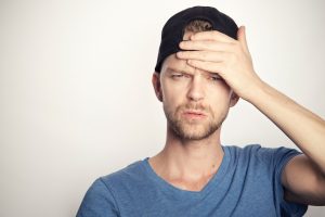 A man hold his head in pain and discomfort, depicting the long-term risks of Lortab abuse 
