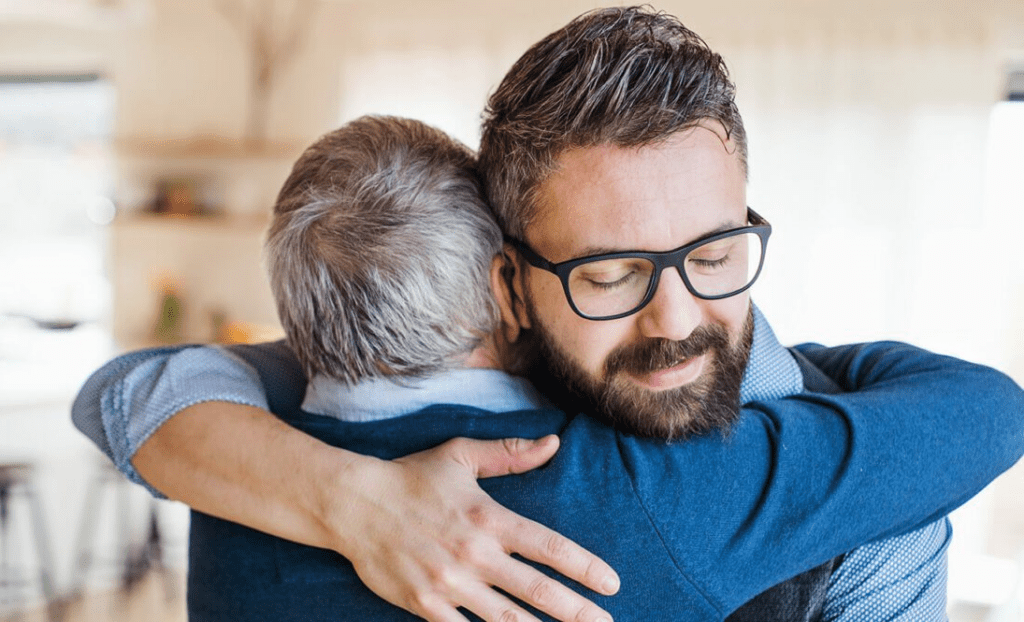 An image of a man embracing a family member