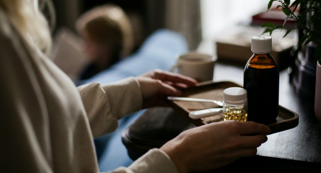 a woman is holding a tray with cough syrup on it to represent the question: is codeine a narcotic?