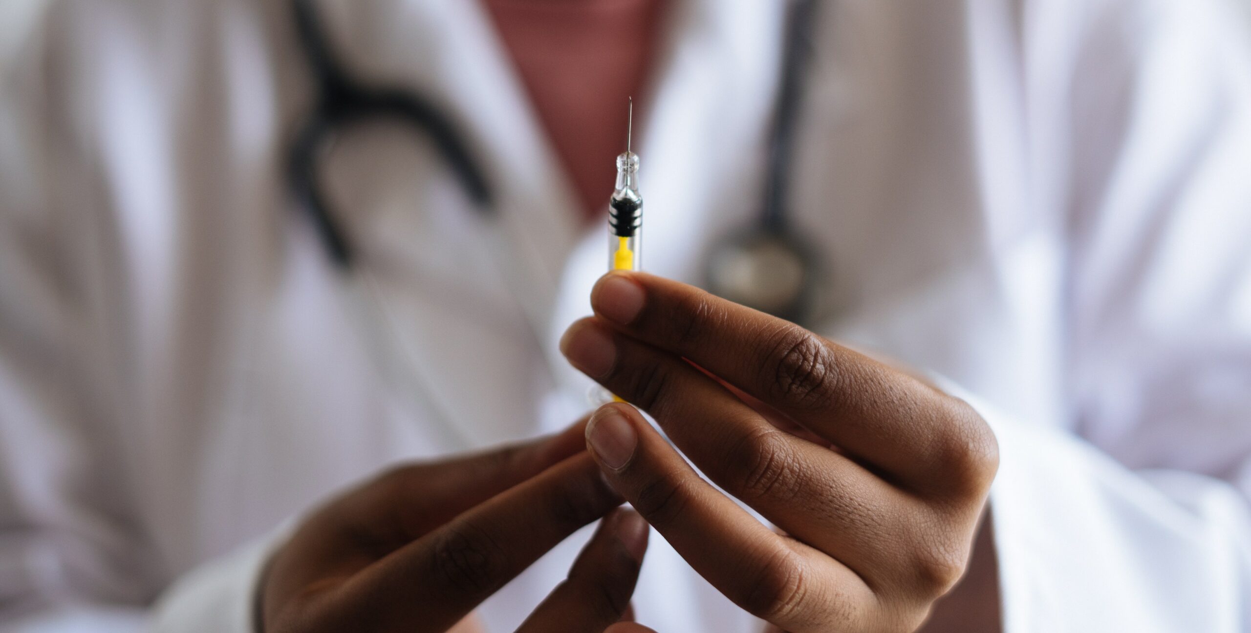 An image of a medical professional holding a shot to represent the question: "how does the vivitrol shot work?".