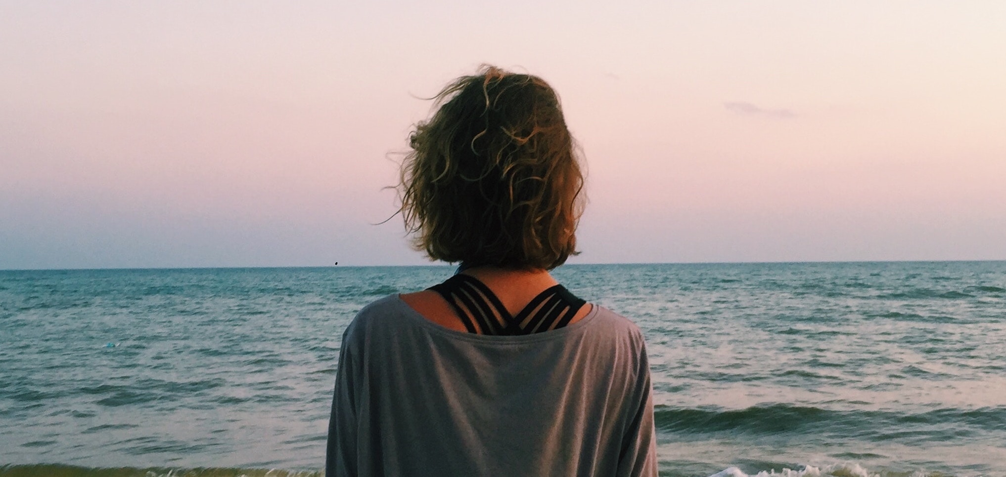 A woman looks out at the ocean representing prescription drug detox.