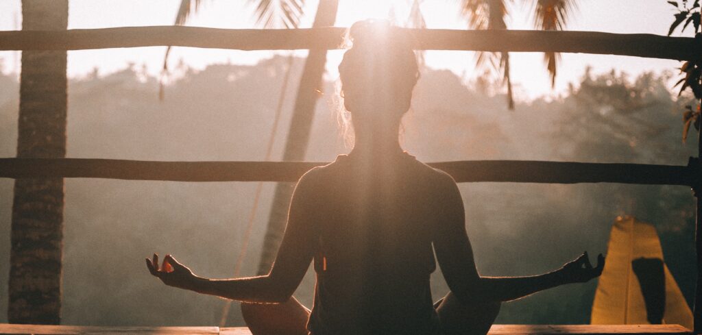a woman sits doing yoga to represent yoga for addiction.