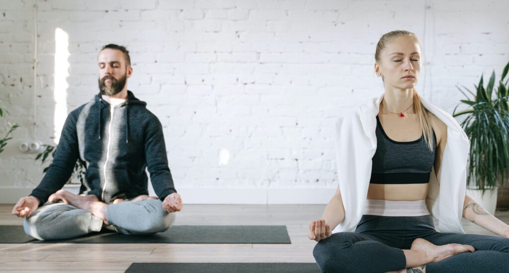 Two people meditate to represent medication for addiction recovery.