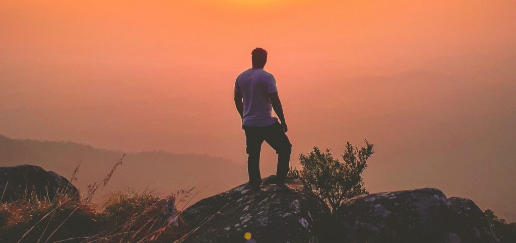 a man stands on a mountain representing the question is tapering off alcohol safe