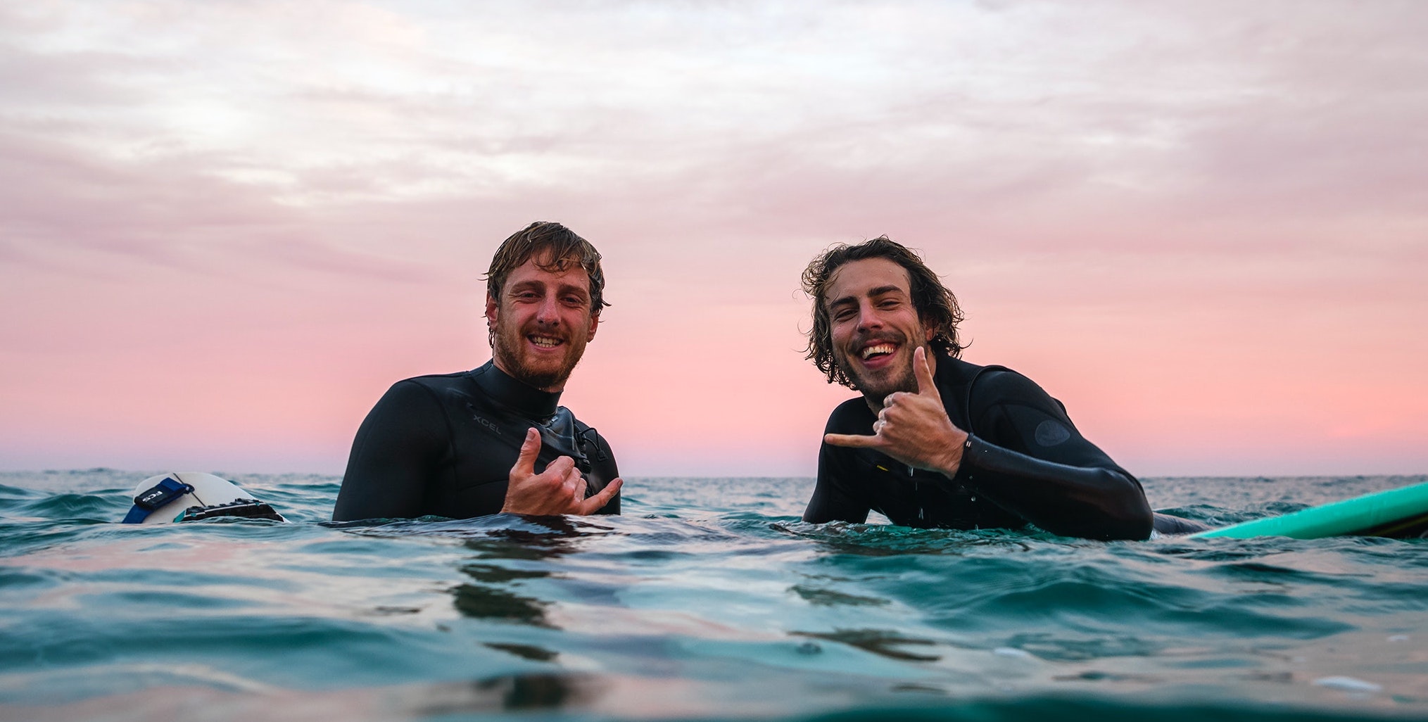 Two people are on surfboards to represent the benefits of surfing on mental health.
