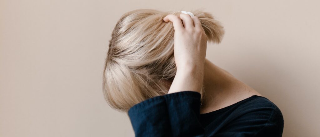 woman puts her hand on hair representing side effects of tapering off zoloft