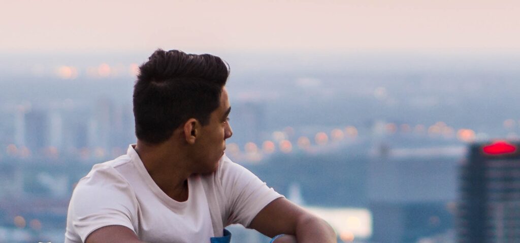 A man looks out at a city to represent opioid addiction.