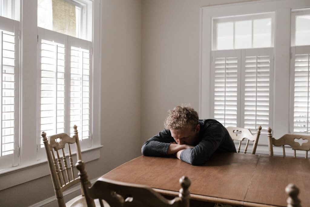 An image of a man alone at a table, as addiction to Adderall can lead to social isolation