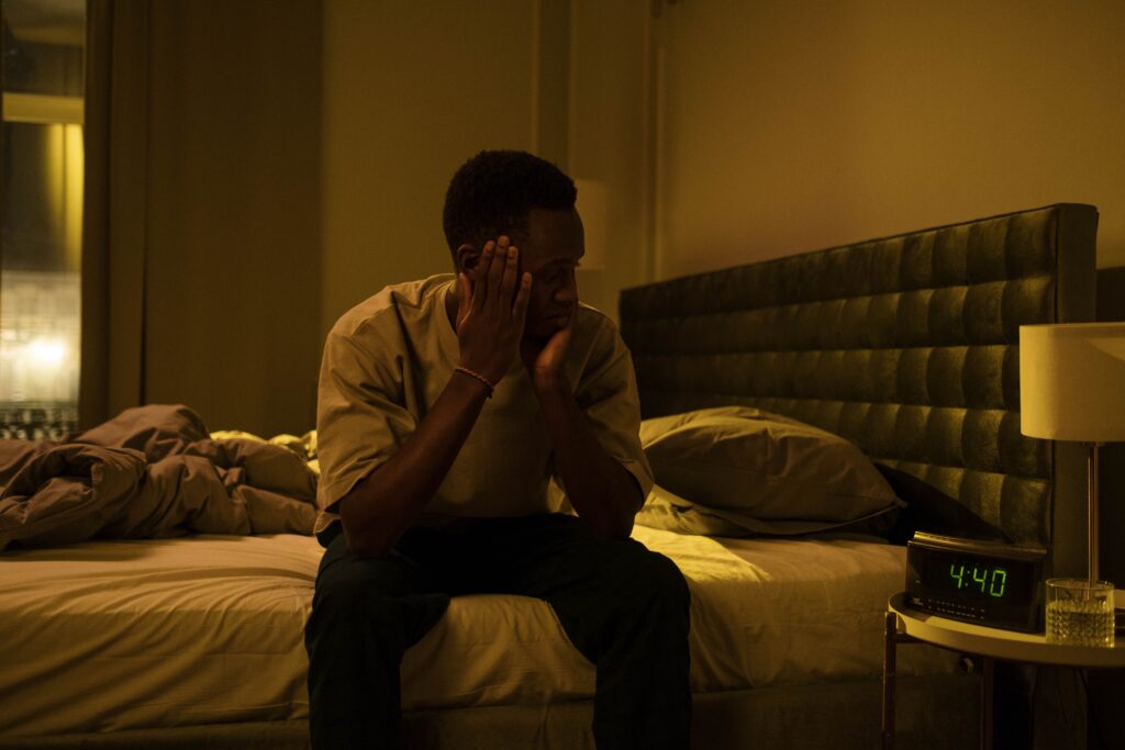 An image of a man struggling with insomnia, a side effect of Adderall addiction