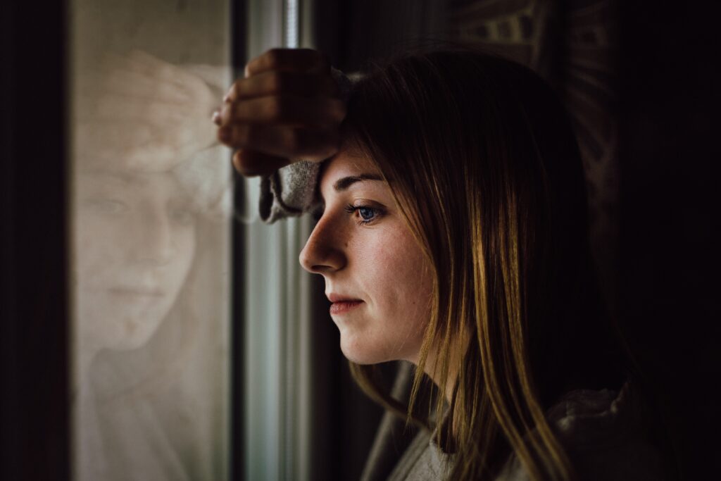 An image of a woman thinking about the things to consider when she looks to find addiction rehabs