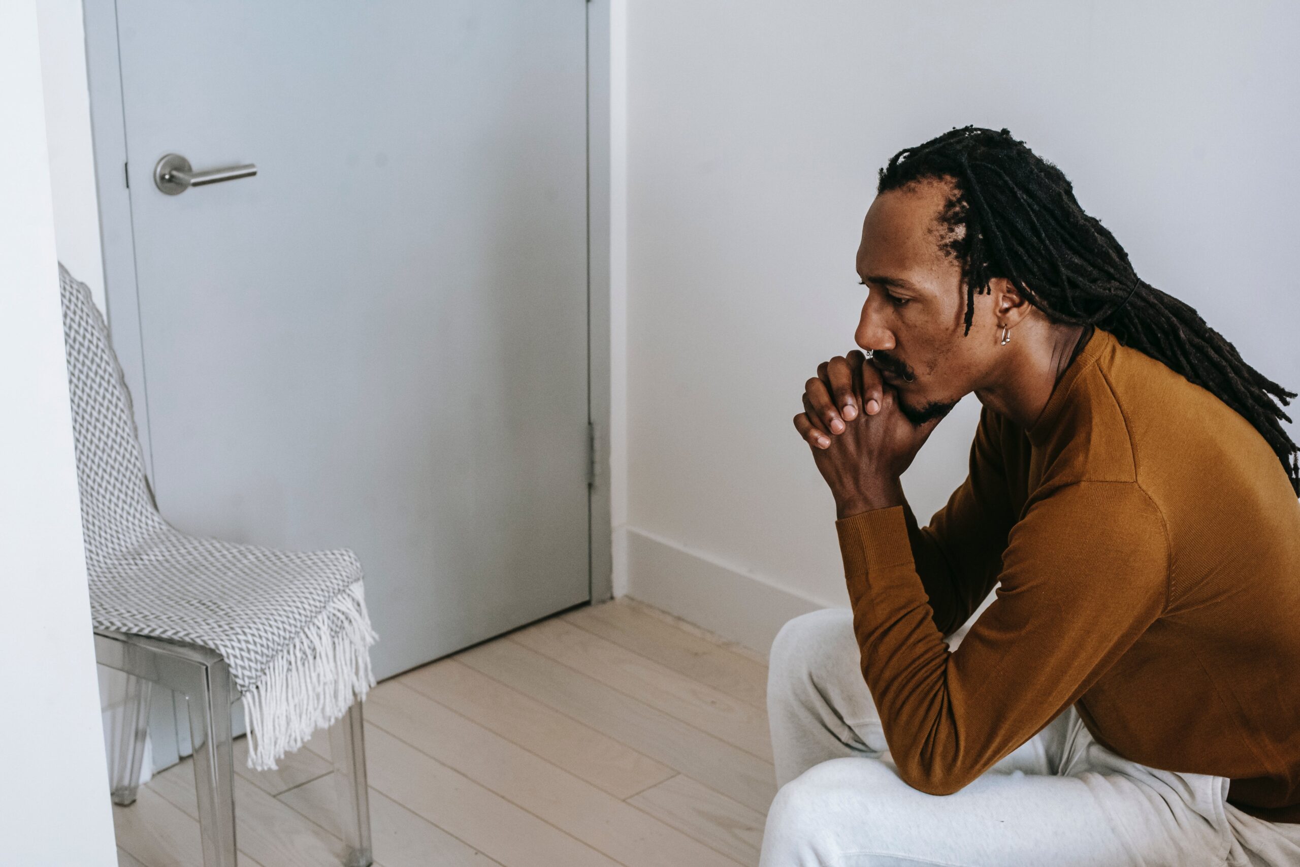 A man sits in deep thought, acknowledging the dangers of mixing Tylenol with alcohol