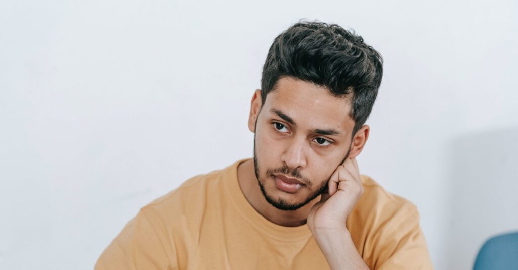 A man is deep in thought representing side effects of ambien and long term ambien use