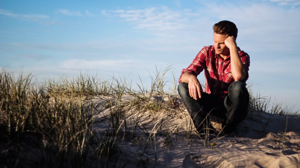 A man sitting on the beach wondering if he has a Vyvanse addiction