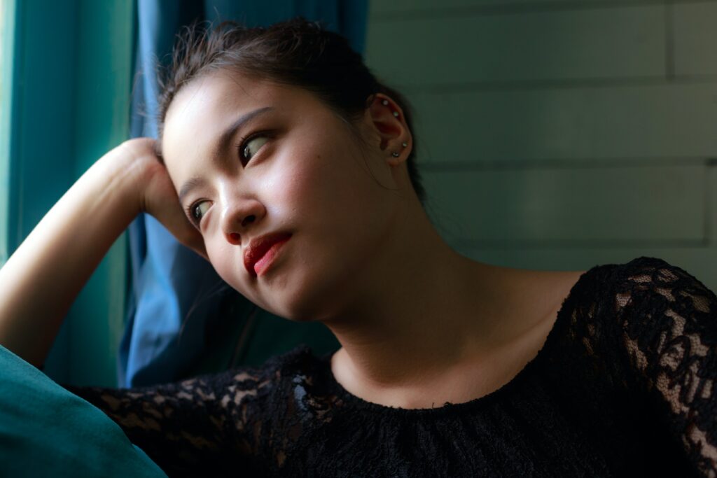 A woman stares out the window representing alcohol addiction symptoms