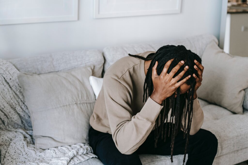 A man holds his hands to his head as he attempts to sleep, showing Alcohol withdrawal and insomnia symptoms