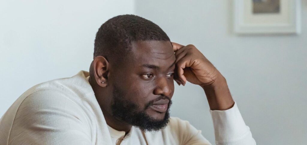 A man in deep thought, wondering how long does alcohol poisoning last