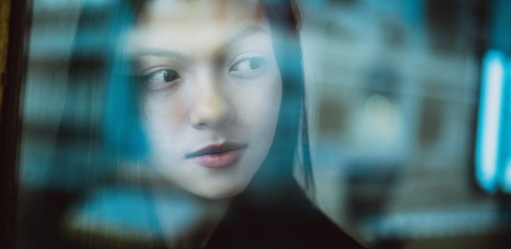 A woman stares out the window after learning about the Common side effects of Xanax
