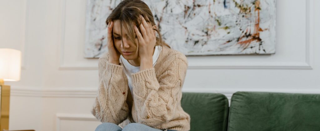 A woman with her hands on her head, depicting the early symptoms of a Xanax overdose