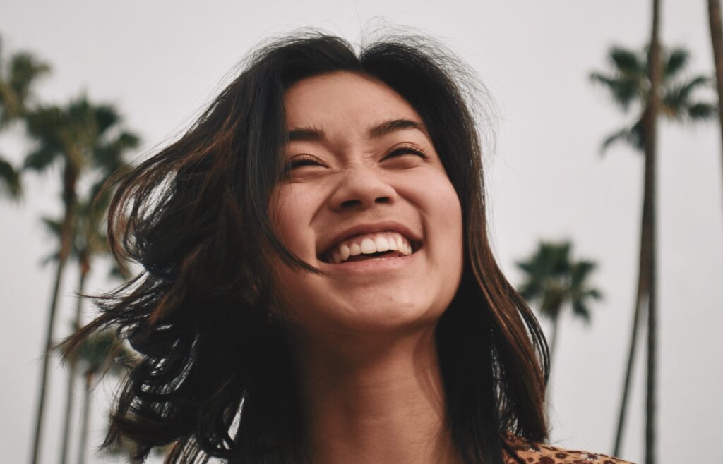 woman smiling in front of california palm trees representing How long is an inpatient mental health stay