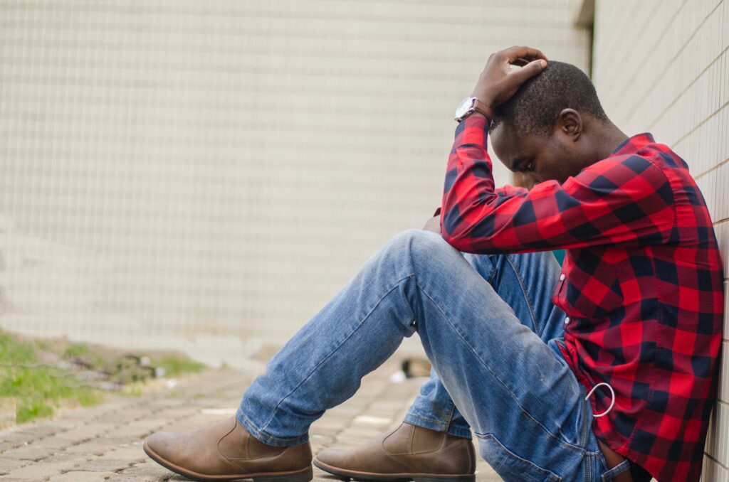 A man sits in discomfort, showing signs of Diazepam addiction symptoms
