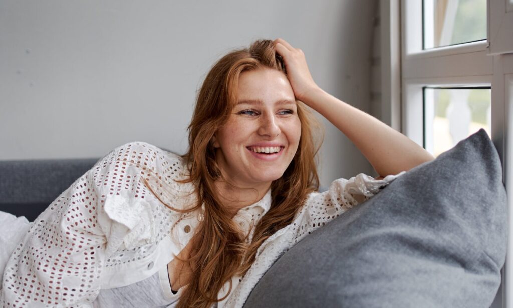 Woman laying on couch smiling representing alcohol withdrawal syndrome medication