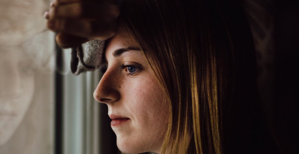 woman looks out window representing cocaethelyne