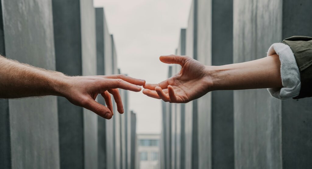 two people reaching out to hold hands representing My son is an addict