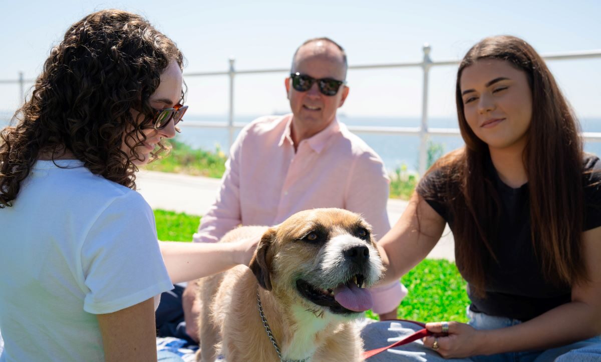 people sitting with dog representing pet friendly mental health facilities near me