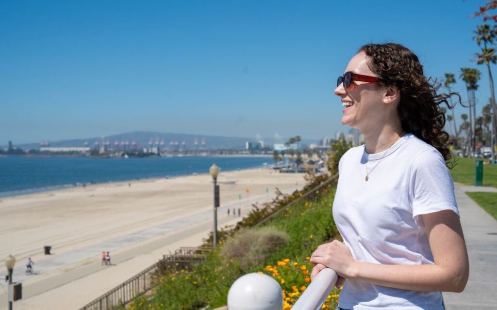 Woman smiling on beach representing Luxury drug and alcohol rehab