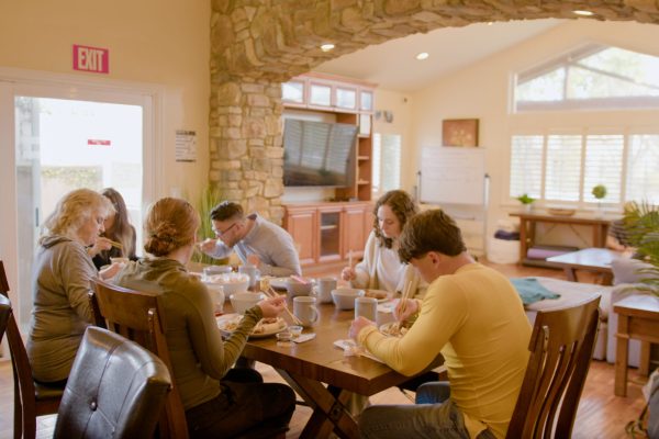 image of people sitting around a table to represent residential alcohol rehab in newport beach